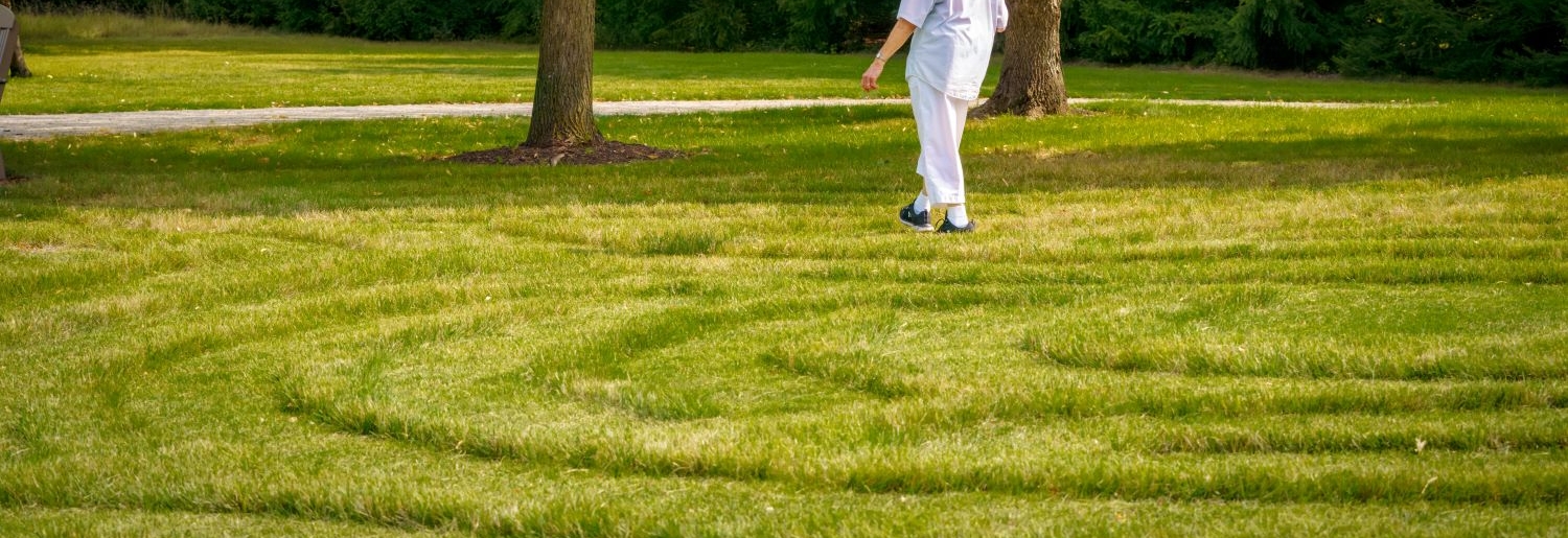 a person walking through a grass labyrinth