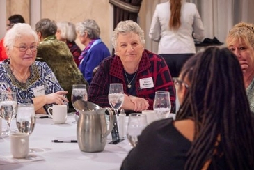 a group of four women engaged in conversation